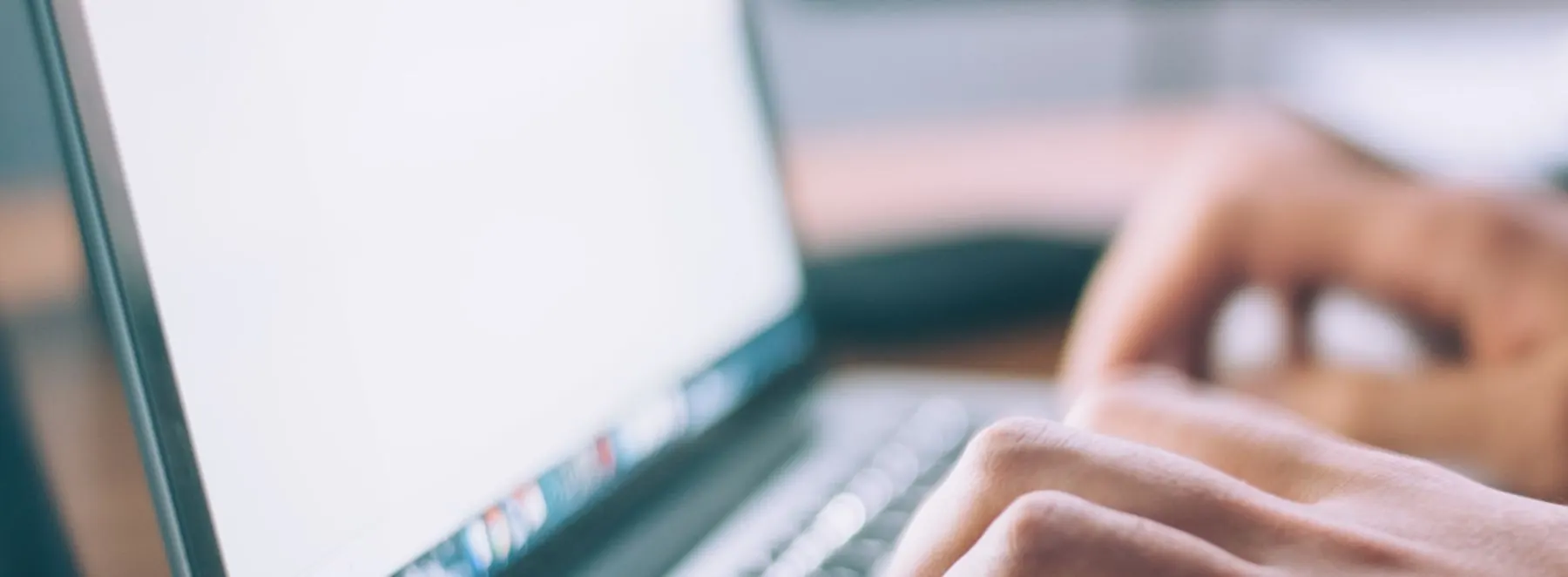Hands typing on a laptop